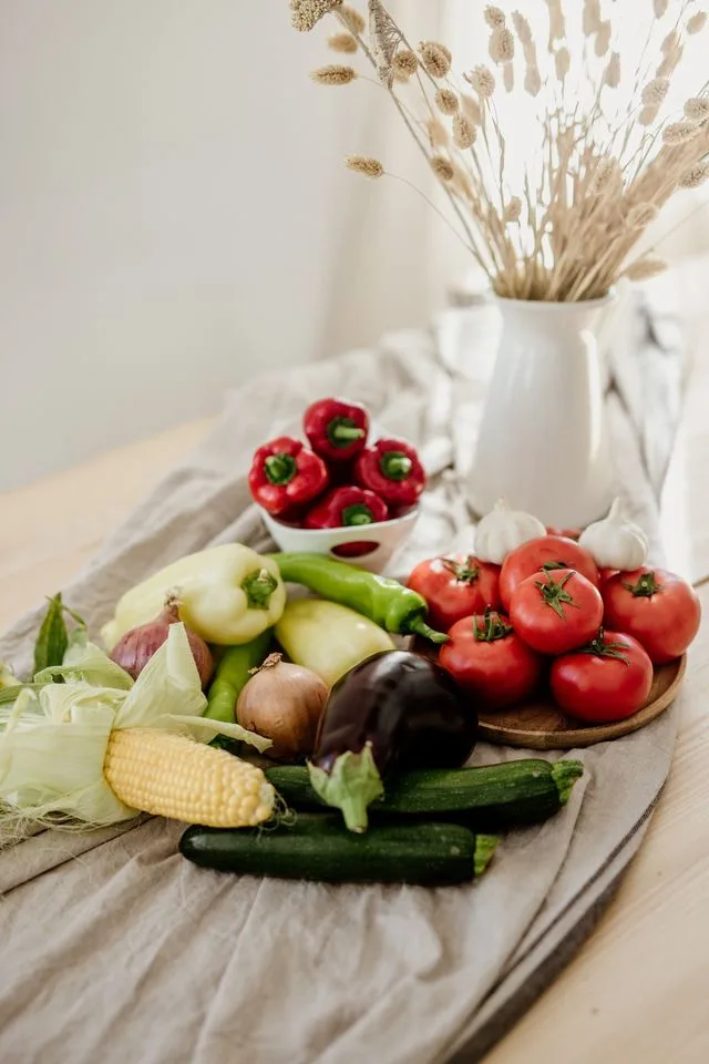 Friss paprika, paradicsom, kukorica és más zöldségek egy asztalon